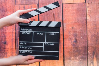 Clapper plakaları, kadınların el ve film clapper ahşap bir backg üzerinde