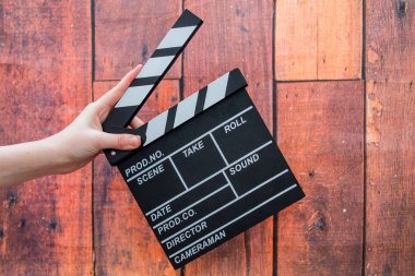 Clapper plakaları, kadınların el ve film clapper ahşap bir backg üzerinde