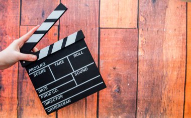 Clapper plakaları, kadınların el ve film clapper ahşap bir backg üzerinde