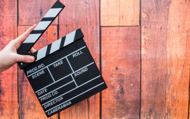 Clapper plakaları, kadınların el ve film clapper ahşap bir backg üzerinde