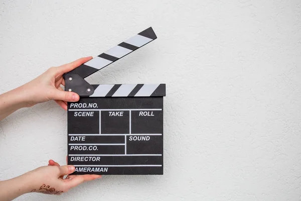 Female hands holding movie clapper isolated on white