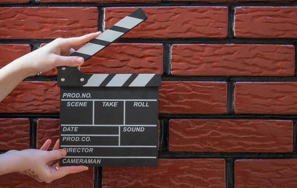 Κλακέτα πλάκες, γυναικεία χέρια και μια κλακέτα ταινία με ένα τούβλο β — Φωτογραφία Αρχείου