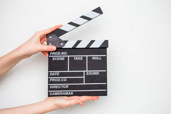 Female hands holding movie clapper isolated on white