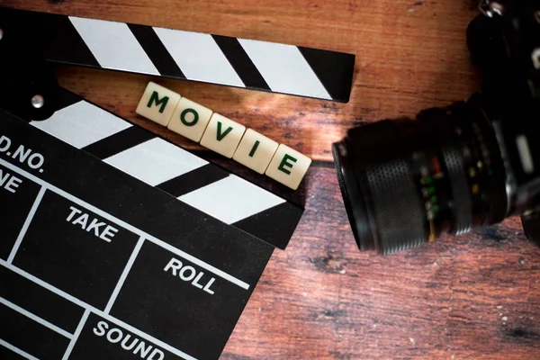 Kino klakier i stary aparat na podłoże drewniane, strzelać film — Zdjęcie stockowe
