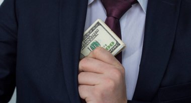 Bir işadamı, nakit toplamını gösterir takım elbise cebine koyar