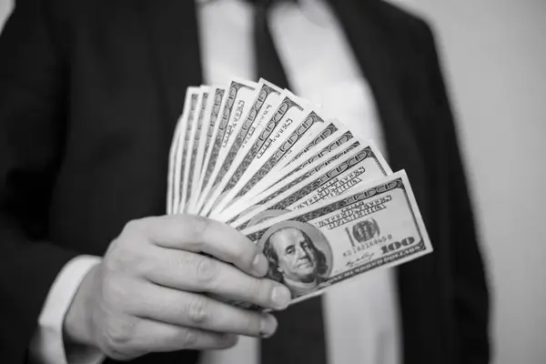 Άνθρωπος των επιχειρήσεων εμφανίζει μια εξάπλωση των μετρητά πάνω από ένα λευκό vintage ΒΑ — Φωτογραφία Αρχείου