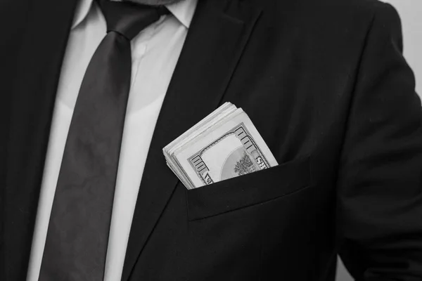 Um homem de negócios mostra uma soma de dinheiro, coloca-o no bolso do fato — Fotografia de Stock