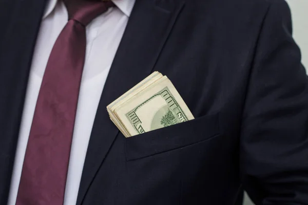 Biznesmen pokazuje sumę gotówki, stawia go w kieszeni garnituru — Zdjęcie stockowe