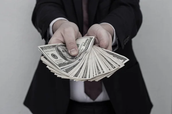 Homem de negócios exibindo uma propagação de dinheiro sobre um branco vintage ba — Fotografia de Stock