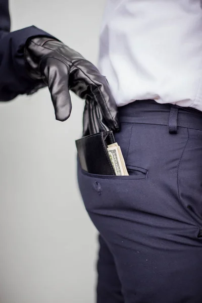 En tjuv tar en plånbok med en kontant från en ficka av en man i en s — Stockfoto