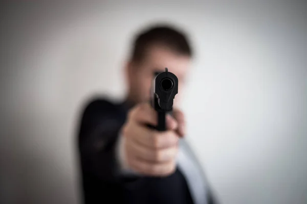 Silahlı bir adama yönettiği bir takım elbiseli bir hırsız nakit, Kalanınıpazartesi alır — Stok fotoğraf