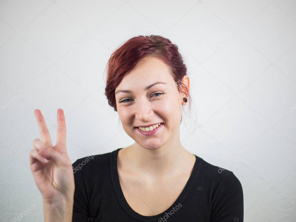 A girl with a smile on her face, a white background behind a gir