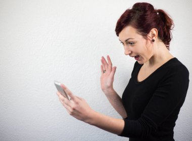 Mobil telefon elinde tutan genç kız yüzünü posi ifade