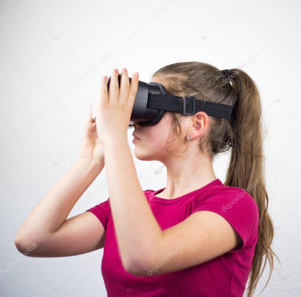 Teenager with virtual reality glasses on the head, enjoying watching, amazing technology, white background, studio