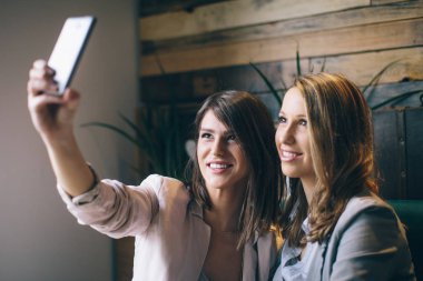 Oturma ve selfie smartphone alarak kızlar