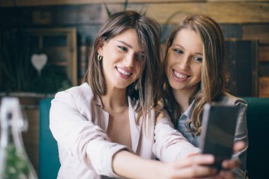 Oturma ve selfie smartphone alarak kızlar