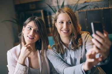 Oturma ve selfie smartphone alarak kızlar