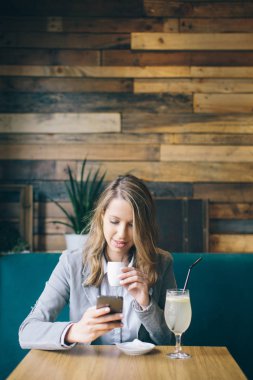 Masada oturan ve smartphone kullanarak kız