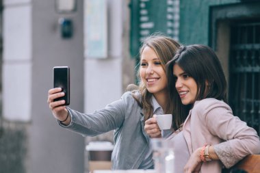 Kafede oturan ve selfie yapma kadın