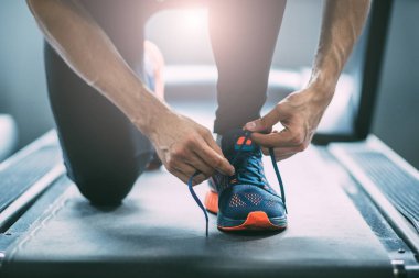 Ayakkabı bağcıkları bağlayan adam