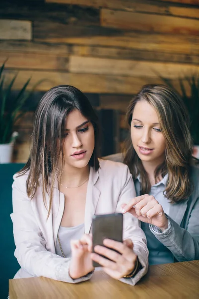 Masada oturan ve smartphone kullanarak kızlar