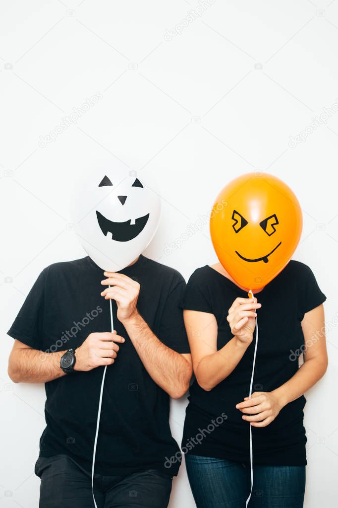 Couple hiding faces with balloons