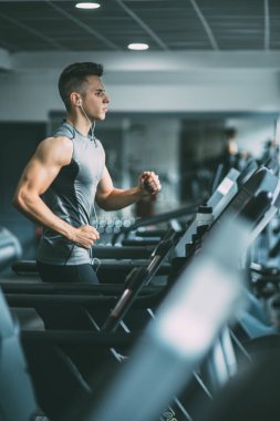 Koşu bandı üzerinde çalışan spor giyim adam 
