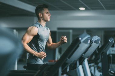 Koşu bandı üzerinde çalışan spor giyim adam 