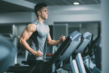 Koşu bandı üzerinde çalışan spor giyim adam 