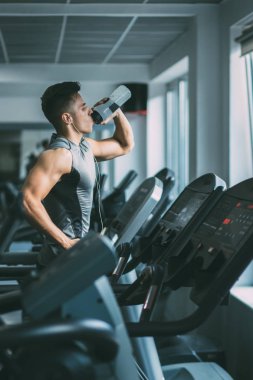 Koşu bandı üzerinde çalışan spor giyim adam 