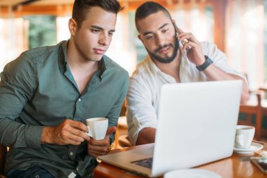 İki adam dizüstü bilgisayar kullanarak