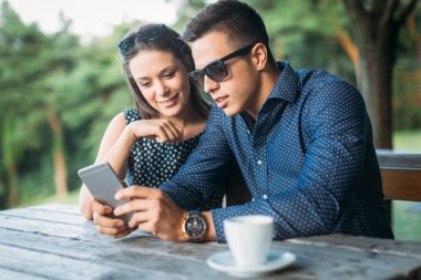 Cep telefonu kullanan genç çift.