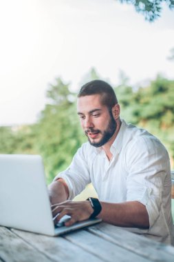 Oturma ve dizüstü bilgisayar kullanarak adam
