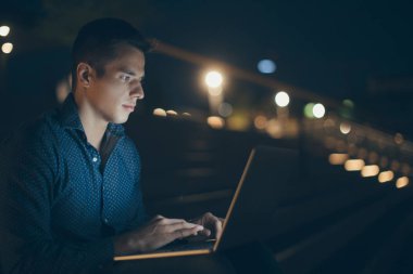 Oturma ve dizüstü bilgisayar kullanarak adam