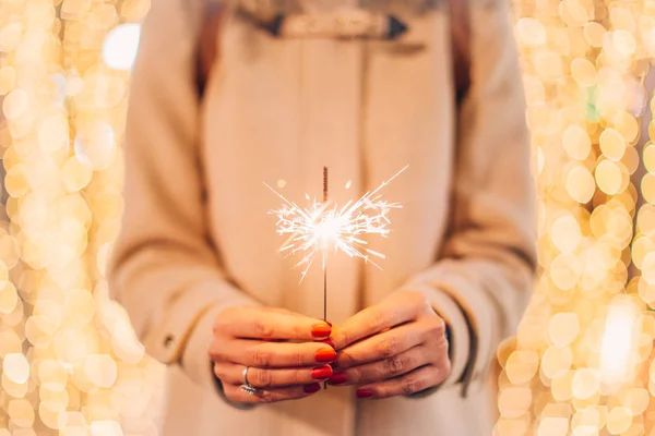 Woman hands holding sparkler — Stock Photo, Image