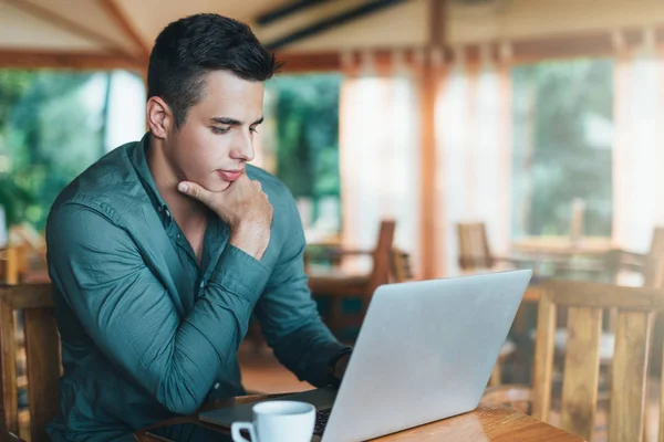 Homem sentado e olhando no laptop — Fotografia de Stock