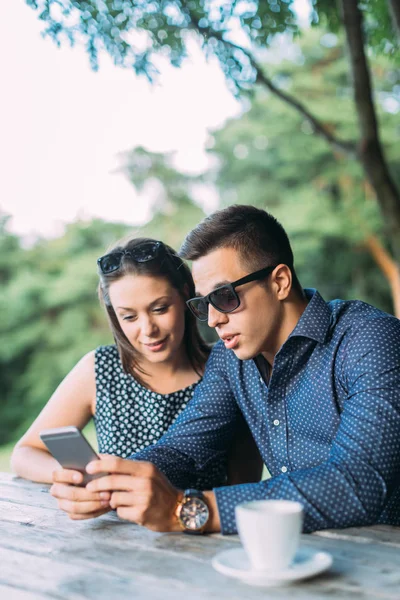 Jovem casal usando telefone celular — Fotografia de Stock