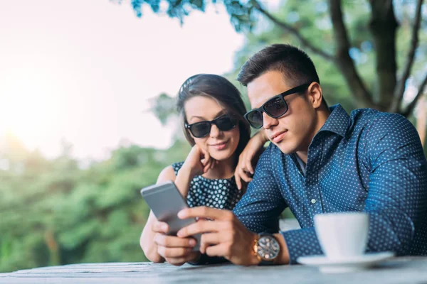 Cep telefonu kullanan genç çift.