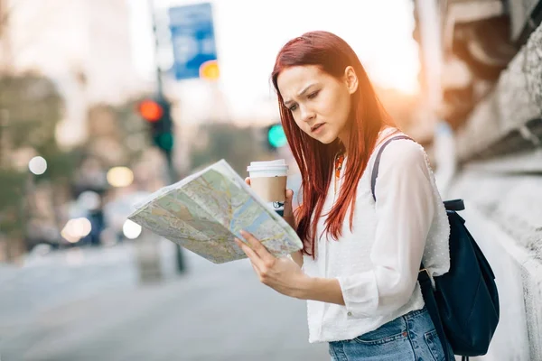 Woman traveler using map in city