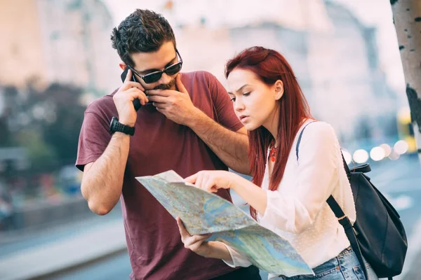 Couple of travelers using map in city — Stock Photo, Image