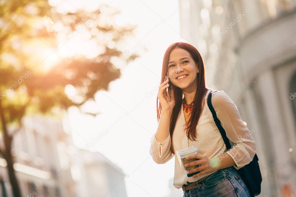 Young woman with mobile phone on street