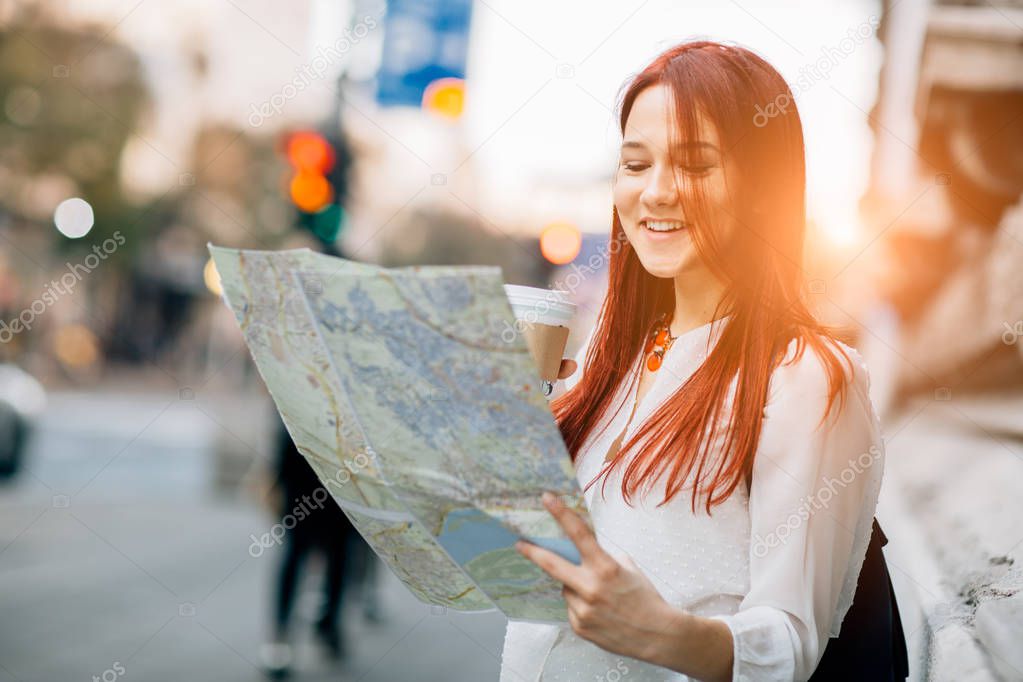 Woman traveler using map in city