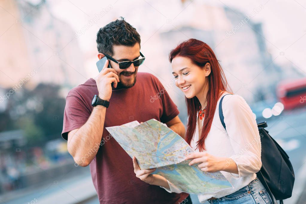 Couple of travelers using map in city