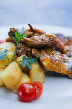Patatesli lezzetli yemek ve beyaz tabakta et.