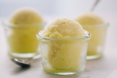 Tahta masada vanilyalı dondurma topları olan küçük cam bardaklar. 