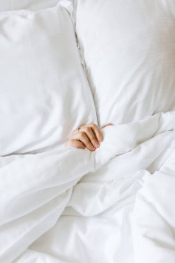 Beyaz battaniyeden bakan insan eli.