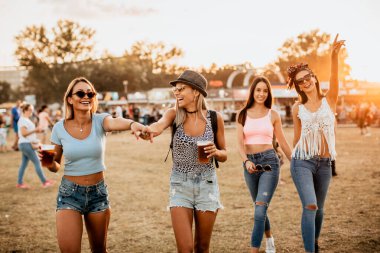 Eğlenceli ve genç kadınlar müzik ve sanat festivalinde vakit geçiriyorlar.
