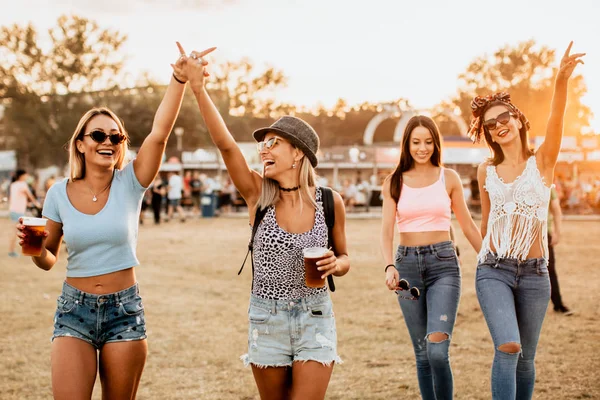 happy girlfriends enjoying start of the weekend on music festival