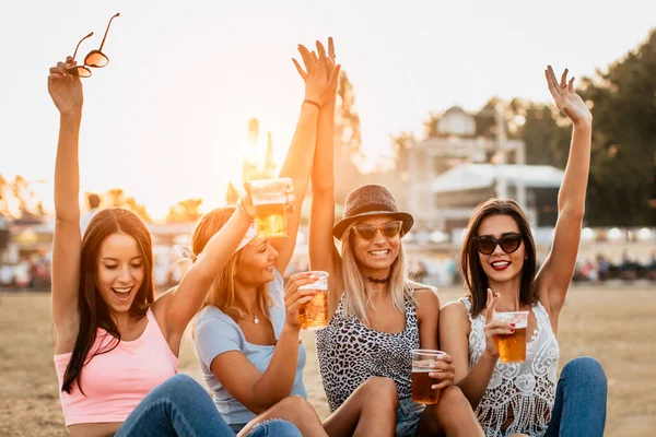 happy girlfriends enjoying start of the weekend on music festival