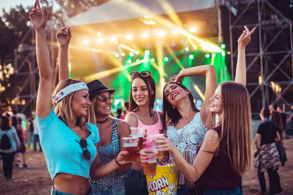 happy girlfriends enjoying start of the weekend on music festival